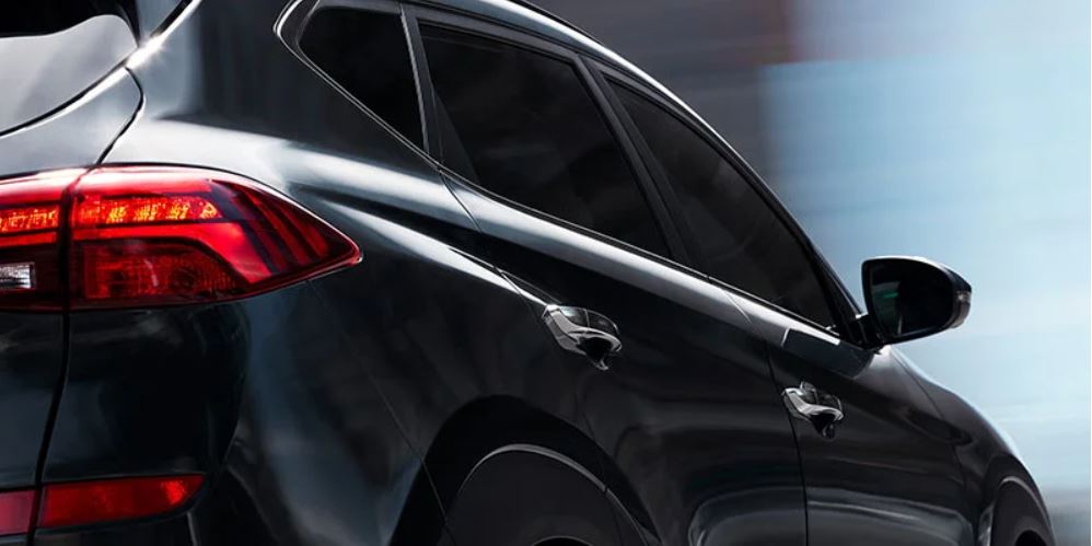 Rear-side view of a black 2022 Hyundai Tucson Hybrid in motion