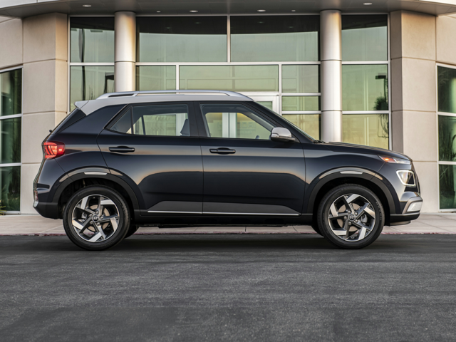 2023 Hyundai Venue parked in front of a modern building, side profile view in dark blue