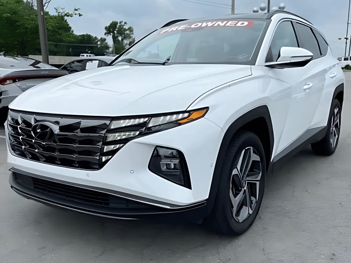 White used Hyundai Tucson SUV with pre-owned sign at Crain Hyundai of North Little Rock dealership