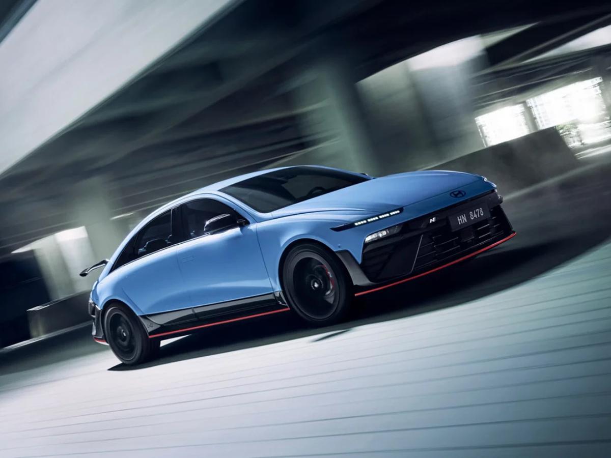 A 2026 Hyundai IONIQ 6 N in Performance Blue captured in a high-speed motion blur, showcasing its aggressive front splitter and aerodynamic profile.